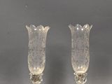 two clear glass vases sitting on top of a table next to each other