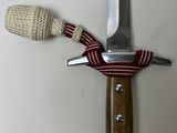 a knife with a rope wrapped around it on a table