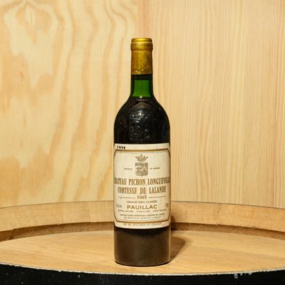 a bottle of wine sitting on top of a barrel