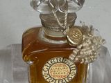 un petit flacon de parfum posé sur une étagère transparente