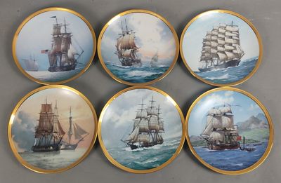 quatre assiettes ornées d'une peinture représentant des bateaux, posées sur une table