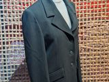 a suit on a mannequin stand in front of a woven wall