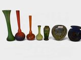 several different colored vases are lined up on a white surface