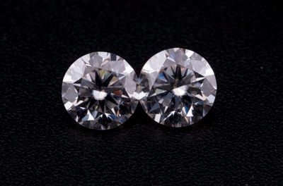 une paire de diamants taille ronde sur un fond noir