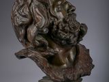 a bronze bust of a man with long hair and beard