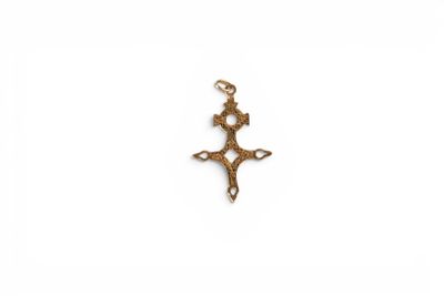 a small gold cross pendant with a cross on it