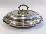 un plat ancien en argent, muni d'un couvercle bombé et d'une poignée décorative