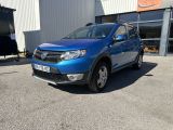 une Dacia bleue garée devant un immeuble