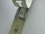 a hand that is holding a watch on a white surface