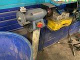 un seau bleu posé à côté d'un tonneau bleu dans un garage