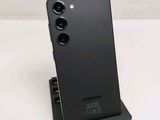 the back of a black samsung phone sitting on top of a white table