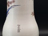 a white vase with a blue and white design on it