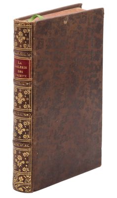 un livre marron aux bords dorés et à la couverture rouge