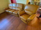 leather couch and loveseat in a living room with wood flooring