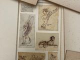 a pile of old papers with drawings on them on a table
