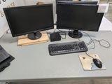 deux écrans d'ordinateur et un clavier posés sur une table