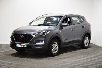 un SUV gris garé dans une pièce au sol à carreaux