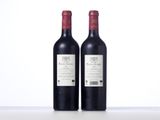 two bottles of red wine sitting on top of a table