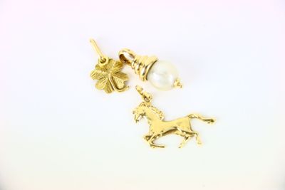 Boucles d'oreilles en forme de licorne et de perle plaquées or sur fond blanc
