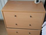 une commode sur laquelle est posée une horloge, dans une chambre à coucher