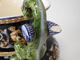 a close up of a vase with a lizard on it