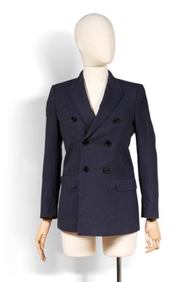 Le mannequin porte un costume bleu et une chemise blanche.