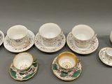 many cups and saucers that are sitting on the table