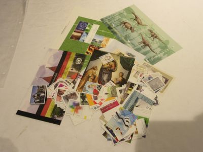 une pile de timbres posée sur une table à côté d'un ordinateur portable