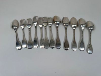 six fourchettes et six cuillères sont alignées sur une surface blanche