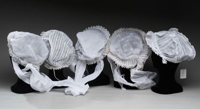 Plusieurs chapeaux sont alignés sur un présentoir noir pour mannequin
