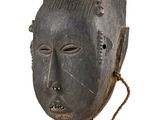an image of a wooden mask hanging on a wall
