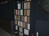 a book shelf with many books on it in a room