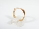 an image of a gold ring on a clear acrylic stand