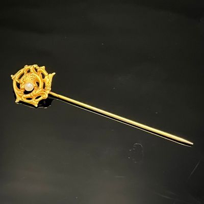 une image représentant un bâton en or orné d'un diamant au centre