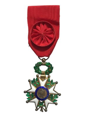 un gros plan d'une médaille sur fond blanc, avec un ruban rouge