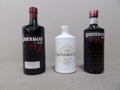 Trois bouteilles de gin sont alignées sur une table