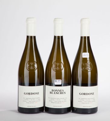 three bottles of wine sitting on top of a white table