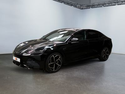 La voiture noire est garée dans la grande salle du showroom.