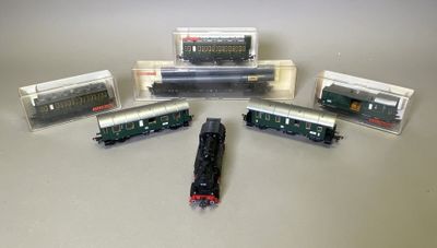 cinq trains miniatures posés les uns à côté des autres sur une table