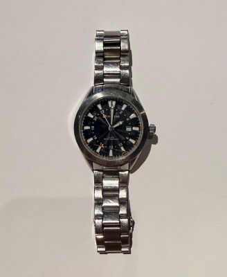 un gros plan d'une montre sur une surface blanche avec un fond blanc