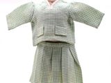 ensemble chemise et jupe à carreaux verts et blancs, présenté sur un mannequin en bois