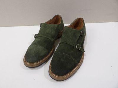 a close up of a pair of green shoes on a white surface