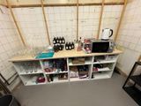 a room with a shelf with bottles and a microwave on it
