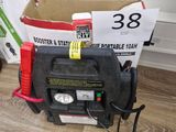 une boîte contenant une batterie et un chargeur, posée par terre