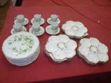 many plates and cups on a table with a red table cloth