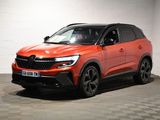 the orange suv is parked in a large room with checkered flooring