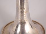 a silver bell that is on a white table