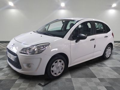 la petite voiture blanche est garée sur un sol en damier