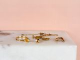 gold rings on a white marble block against a pink background