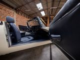 a black and white car in a garage with a door open